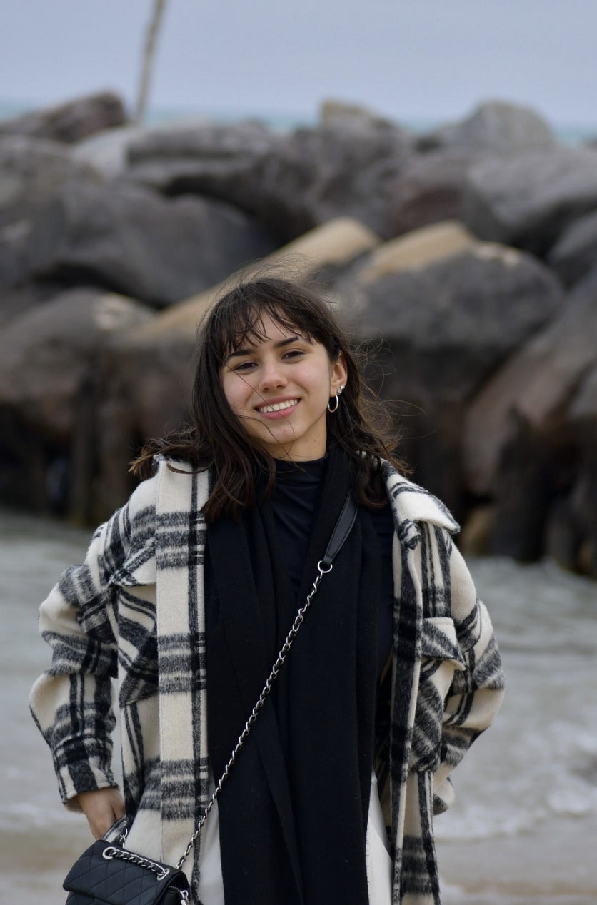 Student standing in front of a natural landscape